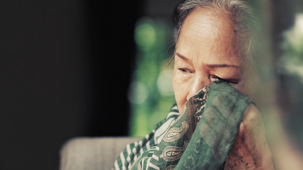 elderly woman wiping her eyes